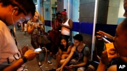 People surf the Internet at a public Wi-Fi hotspot in downtown Havana, Cuba, March 16, 2016.