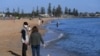 Orang-orang menikmati sinar matahari, ketika negara bagian Victoria mulai melonggarkan pembatasan Covid-19, di pantai Elwood di Melbourne, Australia, 14 September 2020. (Foto: Reuters)