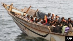 Des migrants clandestins africains assis sur un bateau dans la ville portuaire d'Aden, au sud du Yémen, le 26 septembre 2016.