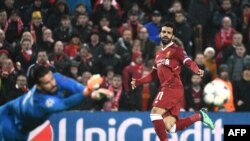 Mohamed Salah, à droite, décoche un tir que renvoie Alisson lors du match entre le FC Liverpool et l’AS Roma, Angleterre, le 24 avril 2018