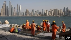 FILE - Laborers work at a construction site at the Palm Jumeirah, in Dubai, United Arab Emirates.