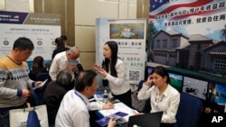 Chinese visitors seek information of the U.S. government's EB-5 visa program at the exhibitor booths in a Invest in America Summit, May 7, 2017.