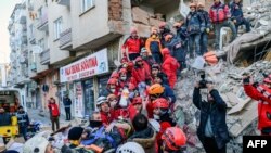 Waokoaji wakiwa wanamtoa mwanamke kutoka katika kifusi cha jengo baada ya tetemeko kupiga katika mji wa Elazig, mashariki ya Uturuki, Jan. 25, 2020.