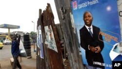 A man walks past an election poster for incumbent President Laurent Gbagbo, as presidential campaigning kicked off Friday, Oct. 15, 2010 in Abidjan, Ivory Coast. Ivory Coast has endured eight years of civil war, and a date for elections has been set and m
