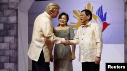 U.S. President Donald Trump shakes hands with Philippines President Rodrigo Duterte as he arrives for the gala dinner marking ASEAN's 50th anniversary in Manila, Nov. 12, 2017. 