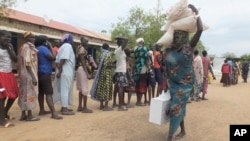 A South Sudanese woman carries food donated by Saudi Arabia's government through the Islamic Council of South Sudan in Juba, South Sudan, April 19, 2017.