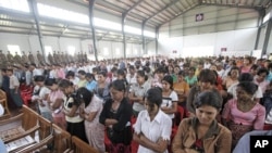 Released prisoners stand up before Burma's prison department chief Zaw Win speaks in a hall at Insein Prison in Rangoon, May 17, 2011.