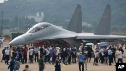FILE - Visitors look at the Chinese military's J-16D electronic warfare airplane during an air show, Sept. 29, 2021, in Zhuhai, China. Some observers are warning that the U.S. faces an uncertain future in which China and other nations could challenge its technological dominance.