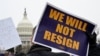 Seorang demonstran membawa poster berisi tulisan "Kami tidak akan mengundurkan diri" dalam aksi demo mendukung pegawai federal AS di depan Gedung Capitol, Washington, pada 11 Februari 2025. (Foto: Reuters/Craig Hudson)