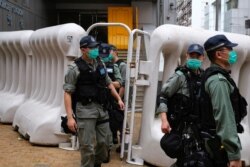 FILE - Riot police are seen during a march against new security laws, near China's Liaison Office, in Hong Kong, China, May 22, 2020.