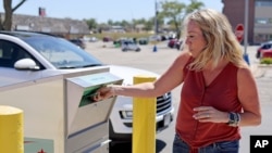 Tracy Astorino drops off her application for a mail-in ballot at the Douglas County Election Commission office in Omaha, Neb., Aug. 19, 2020. Nebraska will send early ballot applications to all registered voters whose counties haven't already done so.