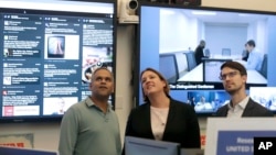FILE – Facebook's Samidh Chakrabarti, director of elections and civic engagement, from left, stands with Katie Harbath, global politics and government outreach director, and Nathaniel Gleicher, head of cybersecurity policy, in the war room in Menlo Park, Calif., Oct. 17, 2018.