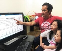 Divo Le helps his children with their schoolwork while his hair salon is closed. (Courtesy of Divo Le)