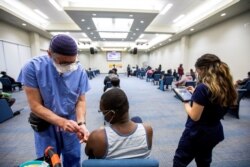 FILE - A health care worker administers the Moderna COVID-19 vaccine at The Church of Pentecost Canada in Toronto, Ontario, Canada, May 4, 2021.