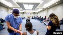 Seorang petugas kesehatan memberikan vaksin COVID-19 Moderna kepada salah seorang warga di Toronto, Ontario, Canada, pada 4 Mei 2021. (Reuters/Carlos Osorio)