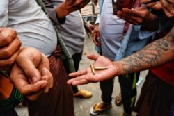 A demonstrator shows bullet shells during a protest against the military coup, in Mandalay, Myanmar, Feb. 20, 2021.