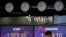 A currency trader talks on the phone near the screens showing the Korea Composite Stock Price Index, left, and the foreign exchange rate between U.S. dollar and South Korean won at the foreign exchange dealing room in Seoul, South Korea, May 25, 2020. 