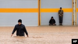 A man crosses a flooded street in the city of Khorramabad in western province of Lorestan, Iran, April 1, 2019. 