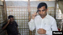 FILE - Mohib Ullah, a Rohingya Muslim leader from the Arakan Rohingya Society for Peace and Human Rights, speaks on a phone at his residence in Kutupalong refugee camp in Ukhiya, Cox’s Bazar, Bangladesh, April 21, 2018.