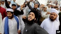 FILE - Pakistanis rally in support of Mumtaz Qadri who was convicted and executed for a blasphemy-motivated killing of a former governor, in Lahore, Pakistan, Feb. 29, 2016.