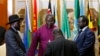 FILE - South Sudan's rebel leader Riek Machar (R) and South Sudan's President Salva Kiir (L) hold a priest's hands before signing an earlier peace agreement in Addis Ababa May 9, 2014.