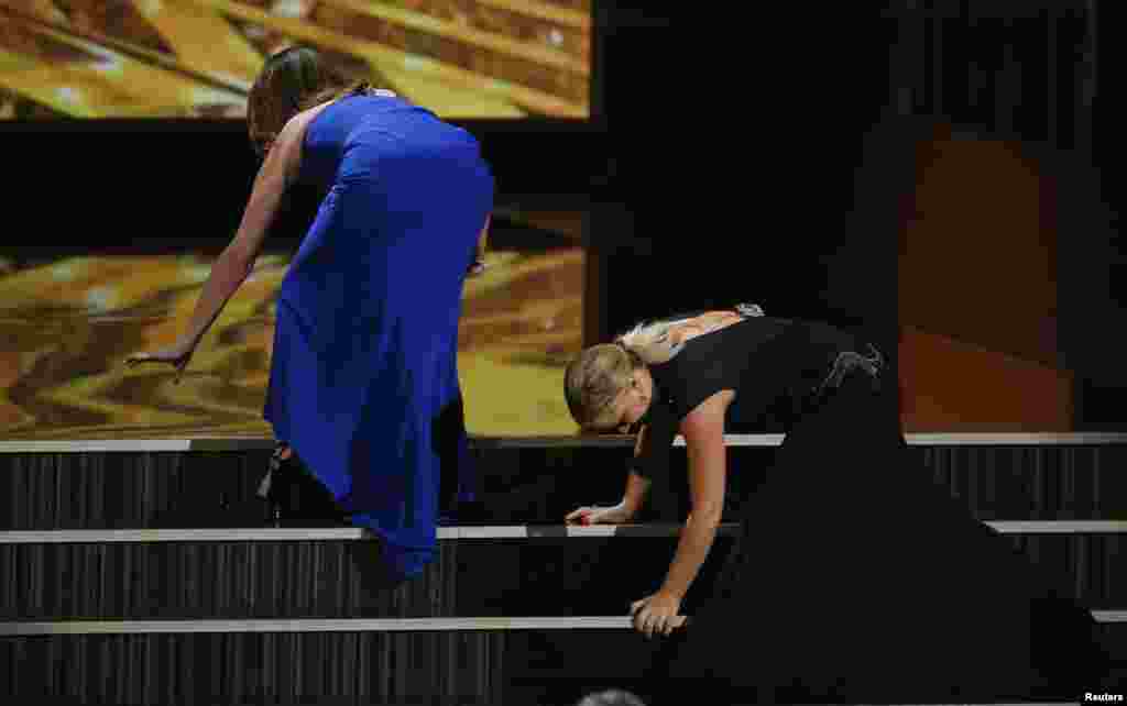 Aktris-aktris komedi Tina Fey dan Amy Poehler berlaku seolah-olah terjatuh saat naik ke panggung Emmy Awards.
