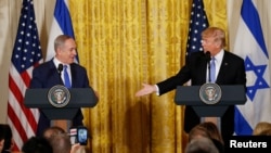 FILE - U.S. President Donald Trump, right, reaches out to Israeli Prime Minister Benjamin Netanyahu during a joint news conference at the White House in Washington, Feb. 15, 2017. 