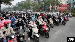 Nhiều người dừng chờ đèn xanh trên một con đường ở Hà Nội, 8/1/2025 (Photo: Nhac NGUYEN/AFP).