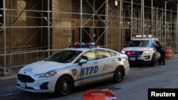 FILE - New York City Police Department (NYPD) officers sit in vehicles outside the District Attorney's Office in New York, March 29, 2023. 