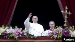 Pope Francis waves as he delivers a "Urbi et Orbi" message from the balcony overlooking St. Peter's Square at the Vatican, April 5, 2015.