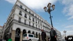 In this April 25, 2020 photo some of nearly 100 Nigeriens arrive in Assamaka, Niger, on foot from Algeria and now must be quarantined for two weeks at the remote Sahara border settlement.