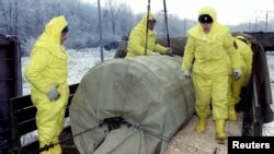 A warhead is loaded from a rail car onto a truck during exercises as Ukraine transferred nuclear weapons to Russia for destruction, Kirovograd, December 7, 1995.