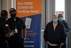 FILE - People stand in line to be tested for the coronavirus disease (COVID-19), at a test center at the Staten Island Ferry Terminal in Staten Island, New York, Nov. 12, 2020.