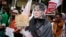 A Muslim woman wears a mask of Myanmar's Foreign Minister Aung San Suu Kyi during a rally against the persecution of Rohingya Muslims, outside the embassy of Myanmar in Jakarta, Indonesia, Nov. 25, 2016. 