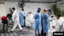 Wisatawan dites COVID-19 di fasilitas pengujian pra-keberangkatan menyusul adanya varian baru COVID, Omicron, di luar terminal internasional di Bandara Sydney di Sydney, Australia, 29 November 2021. (Foto: Reuters)