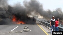 Residents burn tires to block a highway during a protest against the army after an incident with suspected oil thieves in the community of El Palmarito, on the outskirts of Puebla, Mexico, May 4, 2017. 