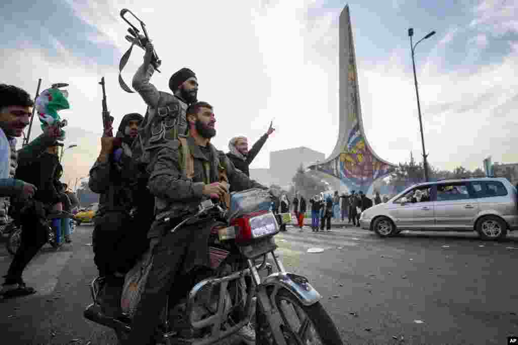 Syrian opposition fighters celebrate the fall of the Syrian government, in Damascus, Dec. 8, 2024. 