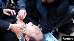 South Korea's opposition party leader Lee Jae-myung falls after being attacked by an unidentified man during his visit to Busan.