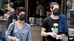 Tunisians hold coffees in a street of Tunis, Tuesday May 26, 2020.