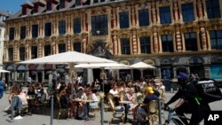 Ljudi uživaju u hrani i piću u bašti restorana u Lilu, na severu Francuske, 9. juna 2021. (Foto: AP)