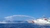 FILE - In this photo provided by the Philippine Coast Guard, a Chinese Coast Guard ship, right, uses its water cannons on a Philippine Bureau of Fisheries and Aquatic Resources (BFAR) vessel, as it approaches Scarborough Shoal in the disputed South China Sea, on Dec. 9, 2023.