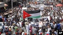 Jordanian police form a line separating the anti-government protesters (back) from government supporters during a demonstration after Friday prayers in Amman, June 10, 2011