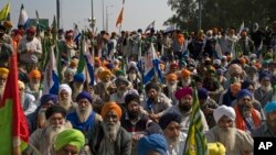 Protesting farmers listen to a leader speak after they were stopped by the police near Shambhu border that divides northern Punjab and Haryana states, almost 200 kilometers (125 miles) from New Delhi, India, Feb.16, 2024. 