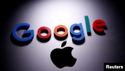 FILE - A 3D printed Google logo is placed on an Apple Macbook in this illustration, April 12, 2020.