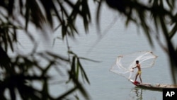 A Cambodian fisherman who lives by the Mekong River casts his net outside Phnom Penh, April 19, 2011. Plans for the first dam across the lower Mekong River are putting Laos on a collision course with its neighbors and environmentalists who fear livelihood