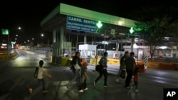 Migrants who are applying for asylum in the U.S. walk to a border bridge as they make their way to their appointment with U.S. authorities, in Nuevo Laredo, Mexico, Sept. 17, 2019. 