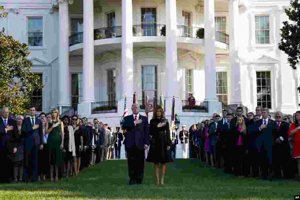 President Donald Trump and first lady Melania Trump stand as "Taps" is played to mark the anniversary of the Sept. 11 terrorist attacks, on the South Lawn of the White House in Washington.