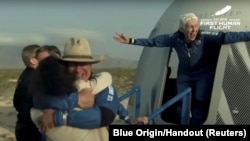 Miliarder Jeff Bezos dan perintis penerbang perempuan, Wally Funk, keluar dari wahana antariksa setelah penerbangan ke antariksa dengan roket New Shepard milik Blue Origin, dekat Van Horn, Texas, 20 Juli 2021.