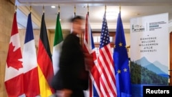 Човек поминува покрај знамињата на земјите-членки на Г7 пред состанокот на министрите за надворешни работи на Г7 во Ла Малбаи, Квебек, Канада, 12 март 2025 година.