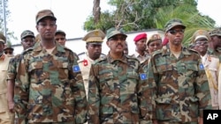 FILE - Somalia's Defense Minister Abdirashid Abdulahi Mohamed (L), watches a a military unit alongside President Mohamed Abdullahi Mohamed (C), and Somali Prime Minister Hassan Ali Khayre (R) during celebrations marking the 57th anniversary since Somali military was founded, in Mogadishu, April 12, 2017. 